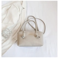 Dettaglio della borsa tote in ecopelle beige con scritte dorate e fibbia in metallo - Bianco