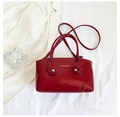 Vista dettagliata di una borsa tote rossa lucida con testo moda su un blazer bianco - Rosso