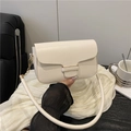White minimalist leather crossbody bag with gold chain and wide strap on a soft fabric - White