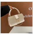Detail der cremeweißen Handtasche mit funkelnder Klappe und goldenem U-förmigem Schloss - Khaki