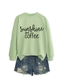 Detail of sunshine and coffee slogan on light green crewneck sweatshirt with denim shorts - Olive Green (Black Font)