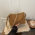 Bolso tote marrón de ante mate con correa de cuero ajustable en un ambiente acogedor - Marrón