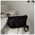 Primer plano del bolso bandolera negro de tela Oxford con bolsillo de cremallera y logo de goma - Rojo