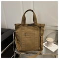 Detalle del bolso tote de lona caqui con etiqueta de moda y bolsillo con cremallera de metal - Marrón