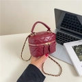 Bolso burdeos acolchado con cadena dorada y doble cremallera en ambiente de estilo vida - Rojo