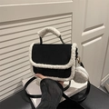Black matte handbag with white plush trim and round coin purse on white book base - Black