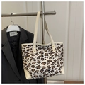 Detail der Leopard-Tasche aus Canvas mit beigen Lederakzenten auf einem Metallständer - Weiß