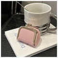 Mini pochette à bijoux rose texture lychee avec fermoir doré posée sur un livre - Rose