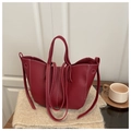 Detailopname van de wijnrode tote bag van lycheeleer met witte contraststiksels - Rood