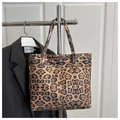 Close-up of leopard print tote bag hanging on a rack with a sleek black blazer background - Khaki