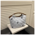 Detalle de bolso acolchado azul claro con bordado de lazo negro y asas de cuero marrón - Azul