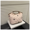 Detalle del bolso acolchado rosa claro con bordados de lazos negros y ribete marrón - Rosa