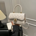Sac bandoulière blanc matelassé avec fermoir doré et poignée, porté par un mannequin - Blanc