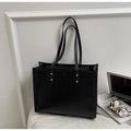 Detalle de un gran bolso tote vintage negro con tachuelas doradas en un entorno de oficina - Negro