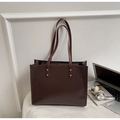 Detalle del bolso tote grande marrón oscuro con asas largas y remaches dorados - Marrón
