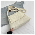 Detailed view of beige quilted crossbody bag with adjustable strap on denim jacket - Off White