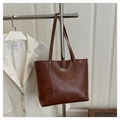 Detalle del bolso tote marrón oscuro con texto dorado y cuero PU de textura natural - Marrón