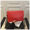Dettaglio di una grande borsa a bustina in pelle rossa con hardware argento e patta elegante - Rosso