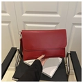 Dettaglio della pochette a busta rossa minimalista rettangolare con tracolla nera - Borgogna