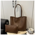 Detalle del bolso tote de cuero mate marrón oscuro con neceser a juego sobre tapete tejido - Marrón