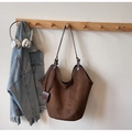 Gros plan détaillé d'un grand sac cabas en daim marron avec une petite pochette assortie - café