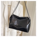 Close-up of black oil wax leather handbag with chain strap and fashion bags engraving - Black