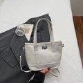 Minimalistische weiße Handtasche aus Kunstleder mit silbernem Verschluss und Riemen - Gebrochenes Weiß