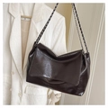 Detailed view of dark brown glossy patent leather texture and chain strap on a flap bag - Brown