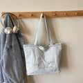 Minimalist light blue-grey tote bag with heart embroidery hanging on a wooden hanger - Light Blue