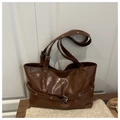 Retro brown tote bag with metal eyelet strap details on a textured wooden surface - Brown