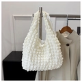Detailed macro view of white popcorn texture and pleated fabric on the shoulder bag - White
