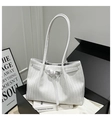 Detalle del bolso tote blanco trenzado con hebilla plateada y textura de espiga en caja de regalo - Blanco