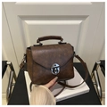 Dettaglio della pelle sintetica vintage marrone scuro e chiusura a scatto della borsa - Marrone