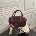 Chic red plaid oval handbag with brown leather straps and gold metal hardware - Red