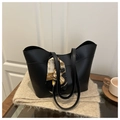 Detail of black bucket bag with elegant silk scarf on handle over a cozy autumn setting - Black