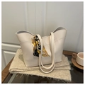 Detail of off-white faux leather tote bag featuring a decorative printed silk scarf handle - White
