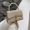 Beige leather crossbody bag with glitter flap and gold hardware held by hand - Khaki