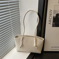 Creamy beige tote bag with embossed lettering and slim shoulder straps in minimalist style - White