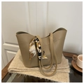 Close-up of khaki bucket bag with decorative printed silk scarf on beige knit blanket - Khaki