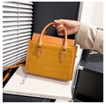 Detailed close-up of mustard yellow tote bag showing smooth and suede-like leather texture - Brown