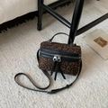 Dettaglio borsa a scatola leopardata con doppia zip e nappe su tappeto neutro - Nero