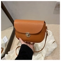 Dettaglio della borsa a sella arancione in pelle martellata con chiusura dorata - Marrone