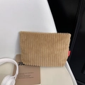 Bolso de pana caqui con textura de ondas y etiqueta de moda sobre una silla blanca - Caqui
