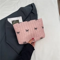 Bolso de mano acolchado rosa con bordado de mariposas junto a un blazer moderno - Rosa