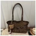 Detalle macro del bolso tote vintage de leopardo con correa de cuero y amuleto de oso - Marrón con Colgante
