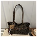 Detalle del bolso tote de leopardo con correas de cuero marrón y colgante de oso de peluche - Café con Colgante