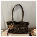 Detalle del bolso tote con estampado de leopardo, asas de cuero marrón y colgante de oso - Verde con colgante