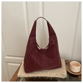 Gros plan sur la texture léopard bordeaux d'un grand sac cabas en cuir élégant - Rouge