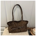 Close-up of leopard print tote bag texture with brown leather strap and metal buckle detail - Brown