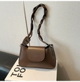 Detail of a brown leather shoulder bag featuring a unique woven knot strap on a book - Coffee without Pendant